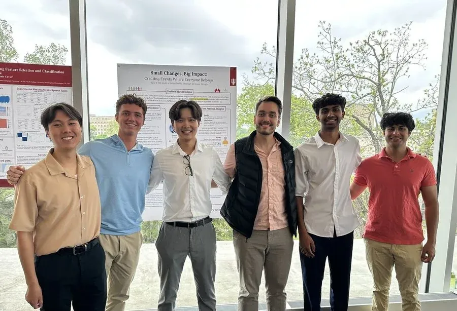 Five Kelley School of Business students beside their inclusive-design poster, Indiana University