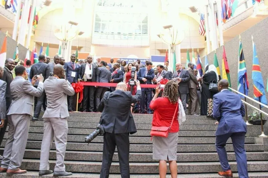 Ribbon-cutting ceremony on the steps of the World Trade Center, Washington, D.C., flanked by the flags of participating nations